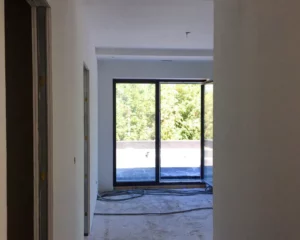 Pièce en chantier avec vue sur terrasse extérieure, préparation pour travaux de rénovation à Colmar